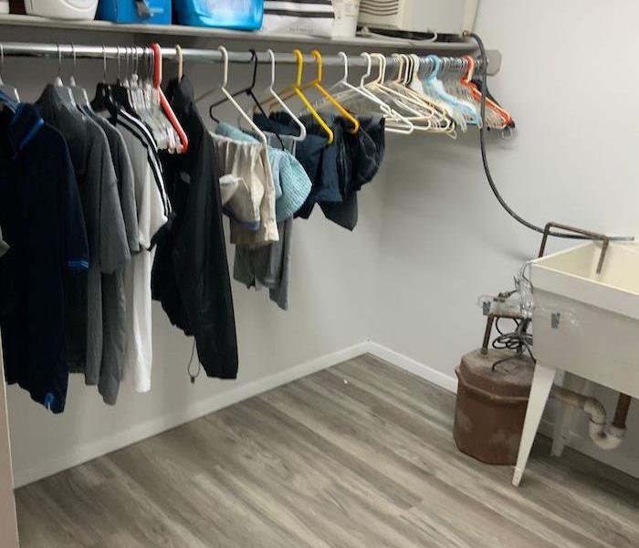 Room with items on hangers and missing baseboards