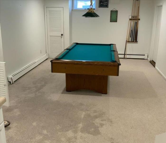 Visibly saturated basement carpeting near a pool table