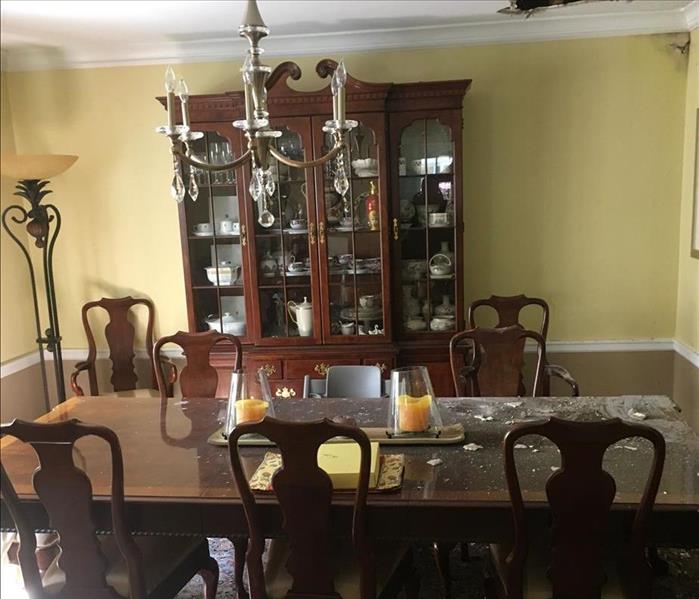 Dining room with furniture with a hole in the ceiling