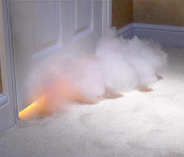 smoke from a house fire coming under a door