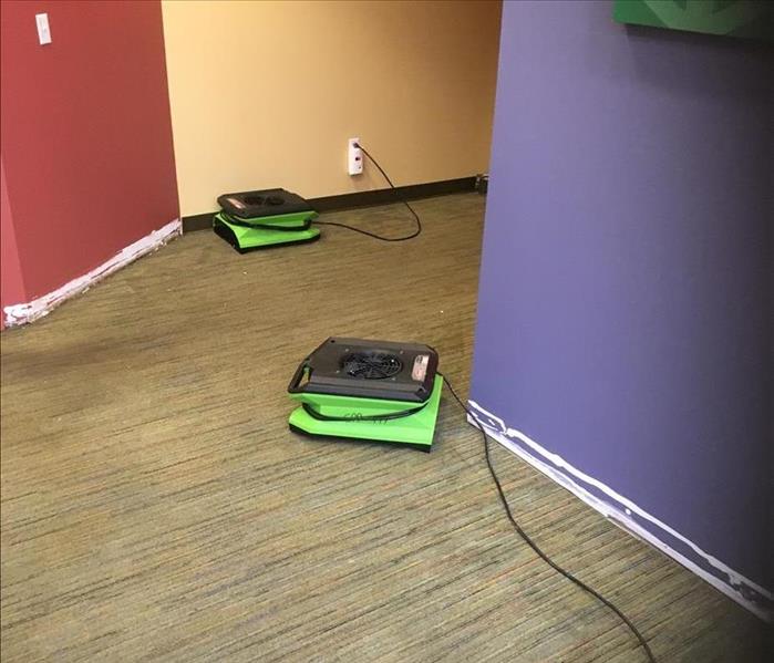 Green air movers drying out a room